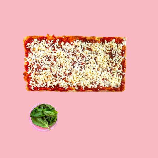 Rectangular Pizza Collective pizza with tomato sauce and white cheese, with a small bowl of basil.